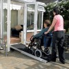Telescopic wheelchair ramp pictures in use over a door threshold